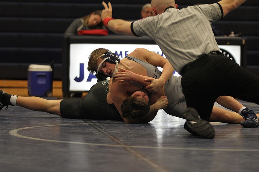 Trying to pin his opponent, sophomore Dalton Harvey pulls the opponents arm up to flip him on his back.