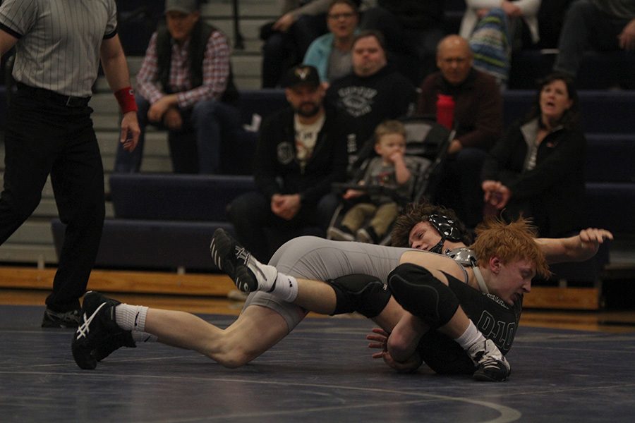 Mid-dive against his opponent, sophomore Carson Dulitz takes the lead in the match.