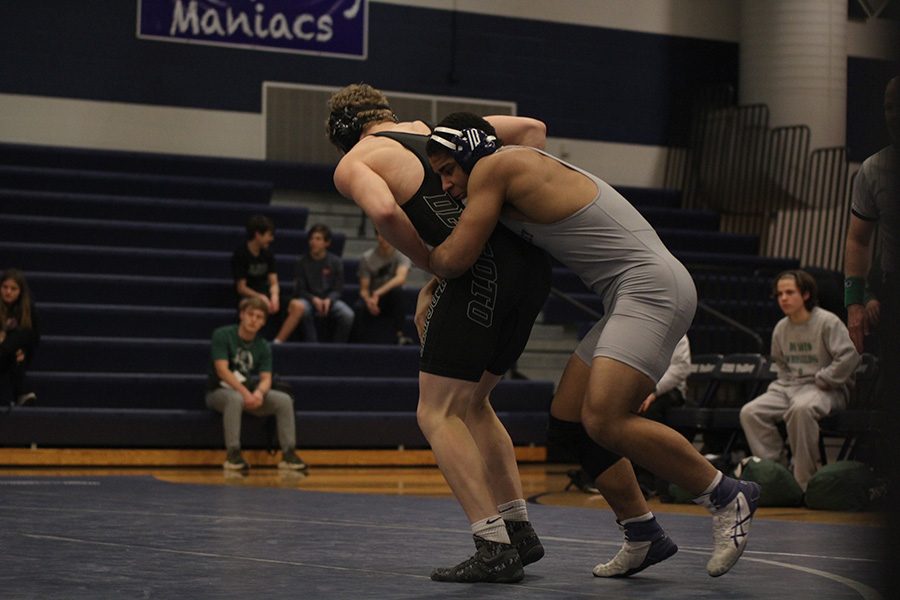 Charging him from behind, junior Tyler Green tries his best to take his opponent down.