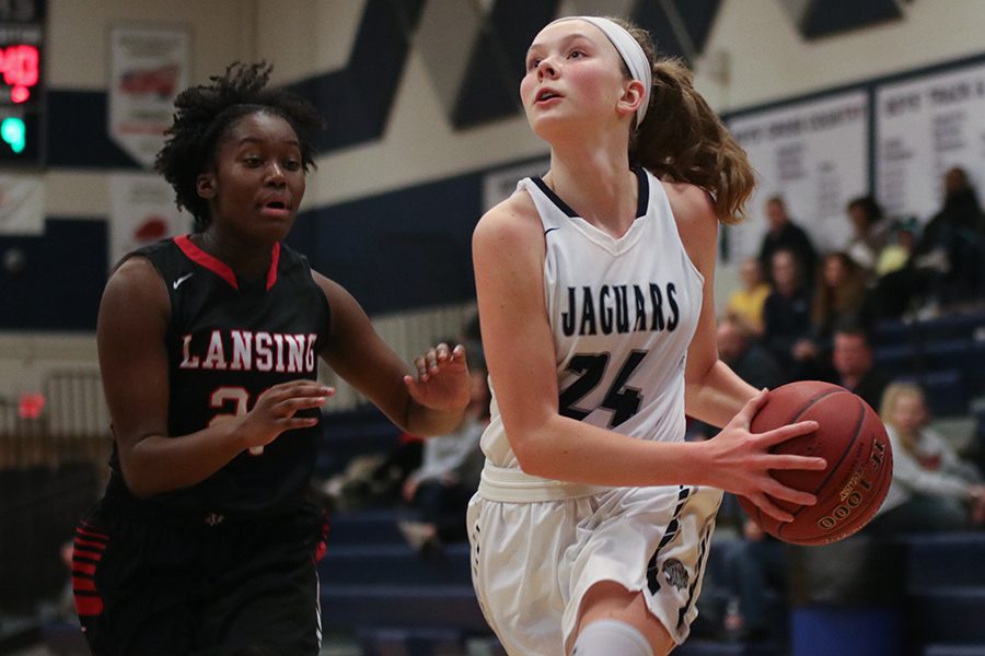 After making a move around a Lansing player, freshman Emree Zars prepares to shoot the ball. Girls basketball played Lansing High School at home on Tuesday, Jan. 15, winning  59-48.