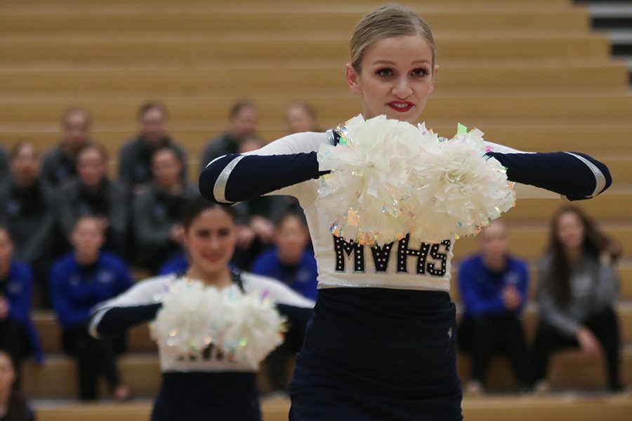 Holding her pom’s right in front of her, senior Bella Line looks into the crowd.  