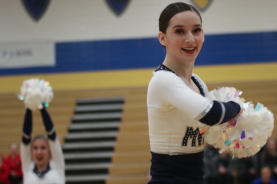 Looking towards the crowd, sophomore Lauren Acree makes a move in the pom routine.