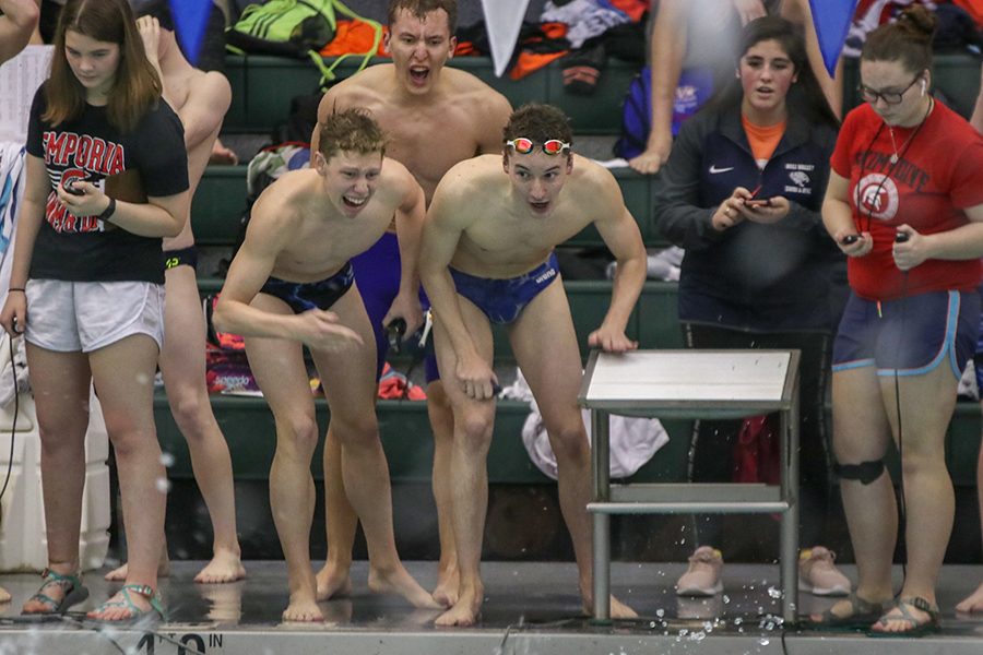 As a swimmer finishes a race, seniors Chris Sprenger and Ethan Forristal cheer on their teammate. 