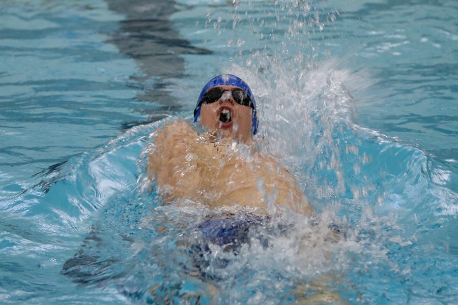 Floating on his back, junior Noah Collings competes in the 200-yard IM relay. 