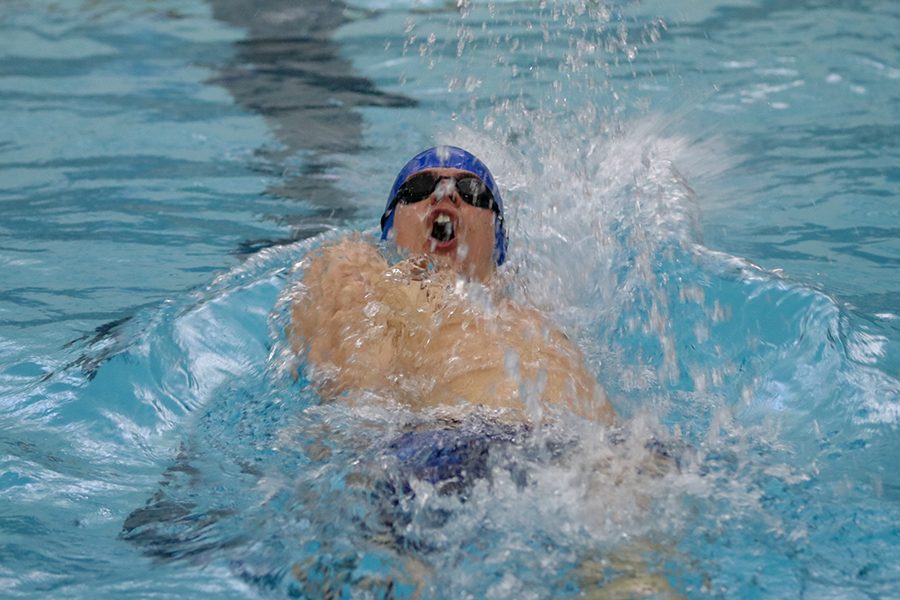 Floating on his back, junior Noah Collings competes in the 200-yard IM relay. 