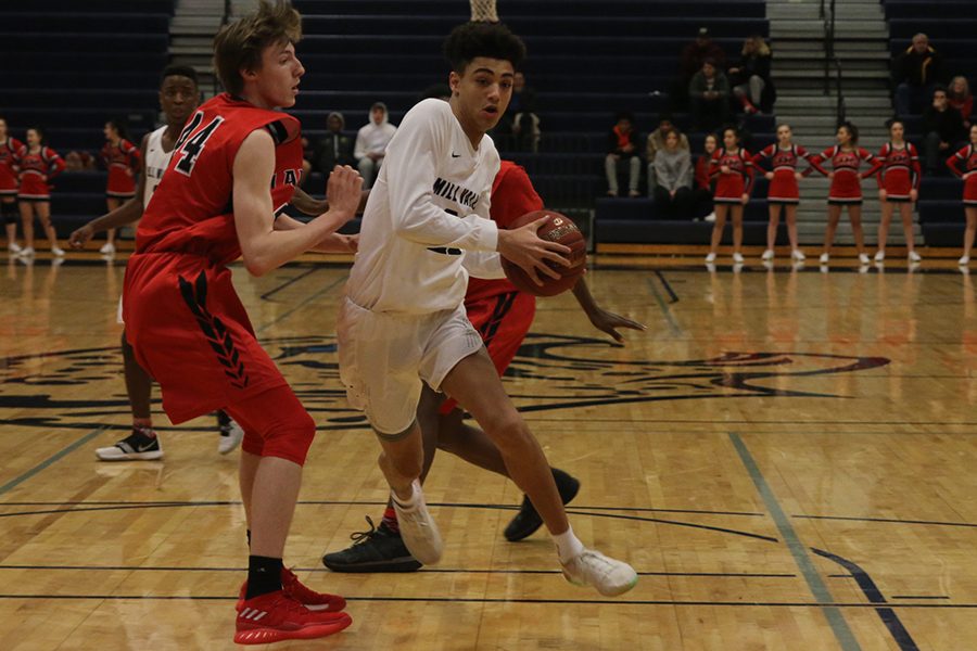 Running past a Lansing defender, freshman Adrian Dimond looks to score.