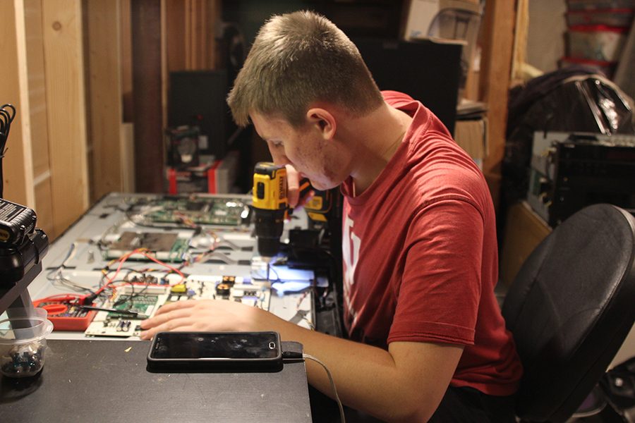 With a drill in his hand, senior Wil Anglemyer attempts to repair the viewing screen on a smart television.