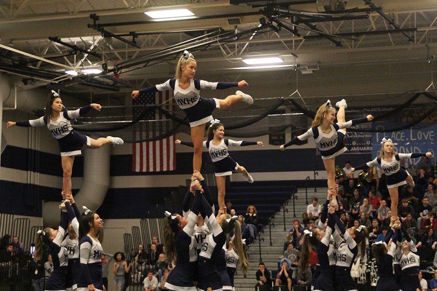 While performing their new routine, the cheerleaders hit a stunt in front of the junior and senior class.