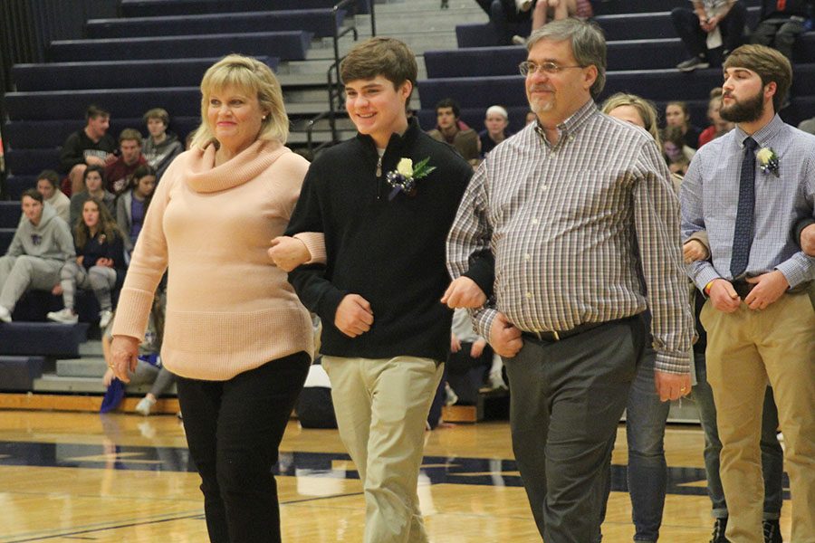 As his name is read aloud, senior WOCO candidate Zach Bossert exchanges smiles across the court with his partner, senior Lauren Harris.