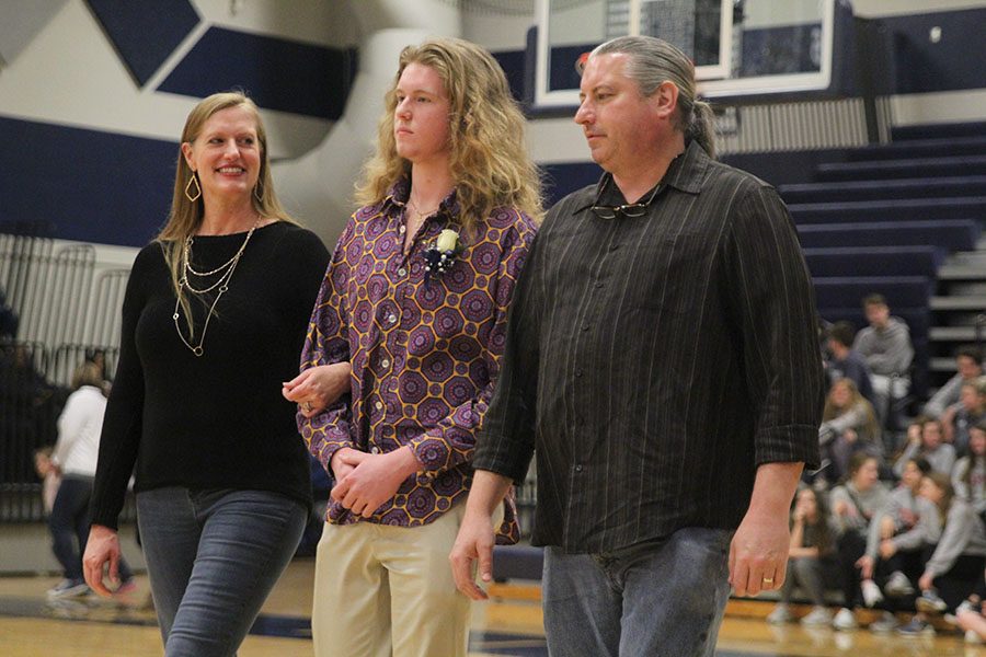 Receiving a smile from his mother, senior WOCO candidate Killian O'Brien walks towards his partner, senior Ashton Rider, as his high school involvement is listed off.