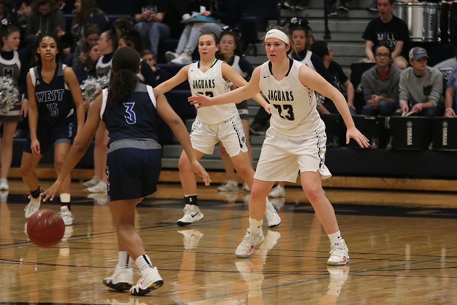 Playing defense in the final quarter, senior Claire Kaifes tries to keep an Olathe West player from getting to the basket.
