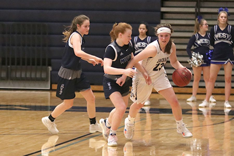 Getting double teamed by two Olathe West players, senior Clair Kaifes tries to find a way to get down court.
