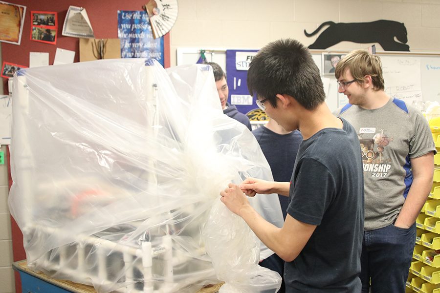 Attaching a zip tie in order to finish bagging the robot, junior Kevin Lee helps his team complete their building process for the season.