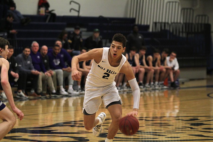 Heading down the court, senior Matty Wittenauer dribbles the ball. 
