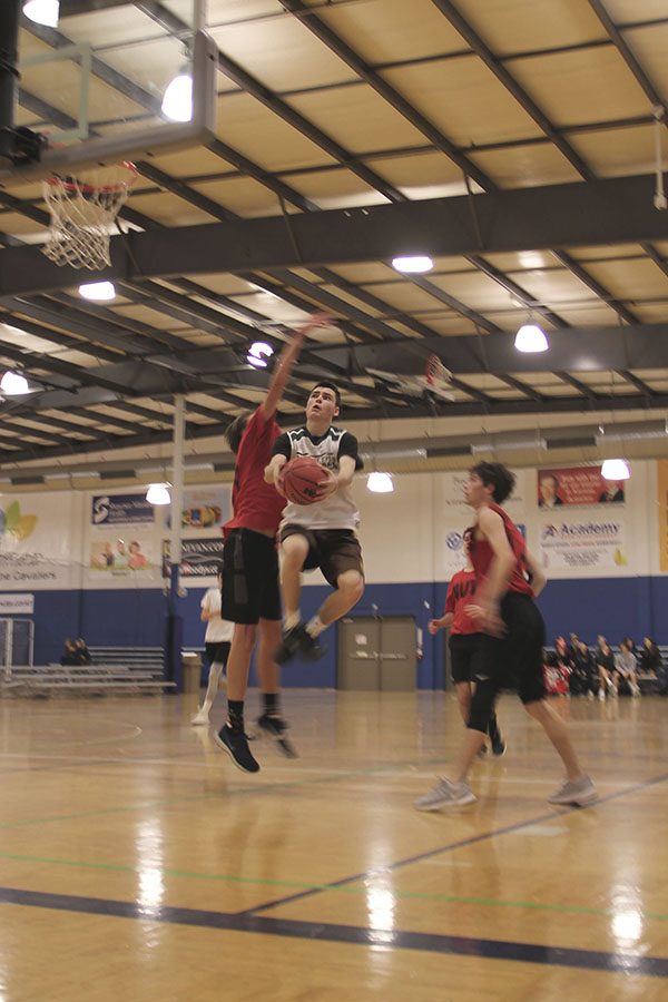 In a basketball game on Tuesday, Jan. 29, senior Collin Prosser jumps up into a defender to try and make a layup. The rec league allows for a casual chance to play classmates. “We just kind of did whatever we wanted on offense,” Prosser said.
