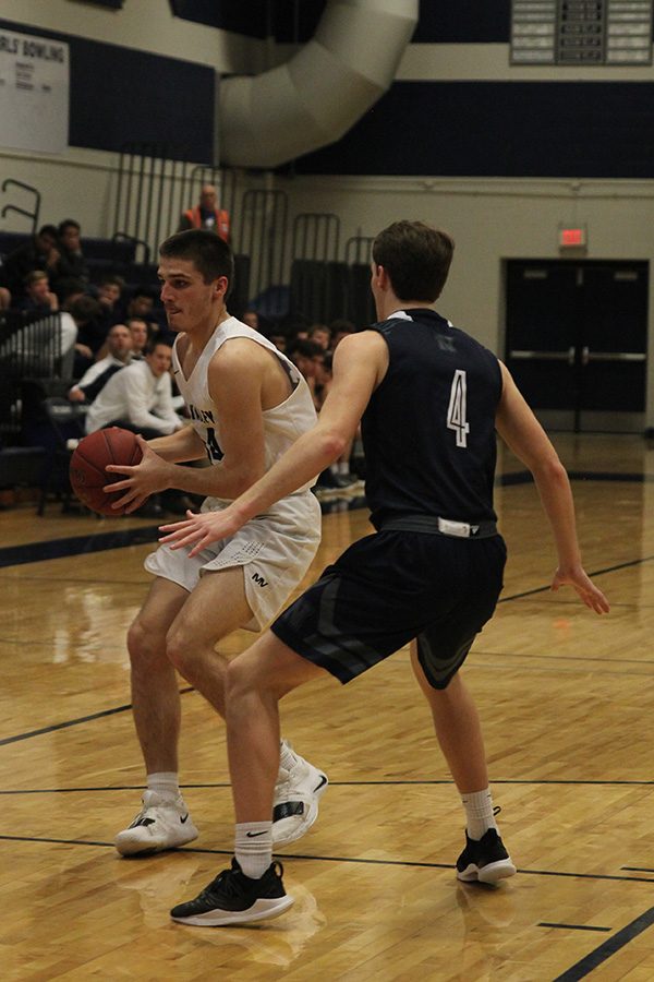 Looking for an open teammate, senior James Smith keeps the ball away from an opponent.