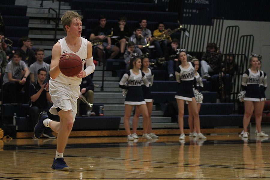 In the first half, senior Nick Davie dribbles the ball down the court.