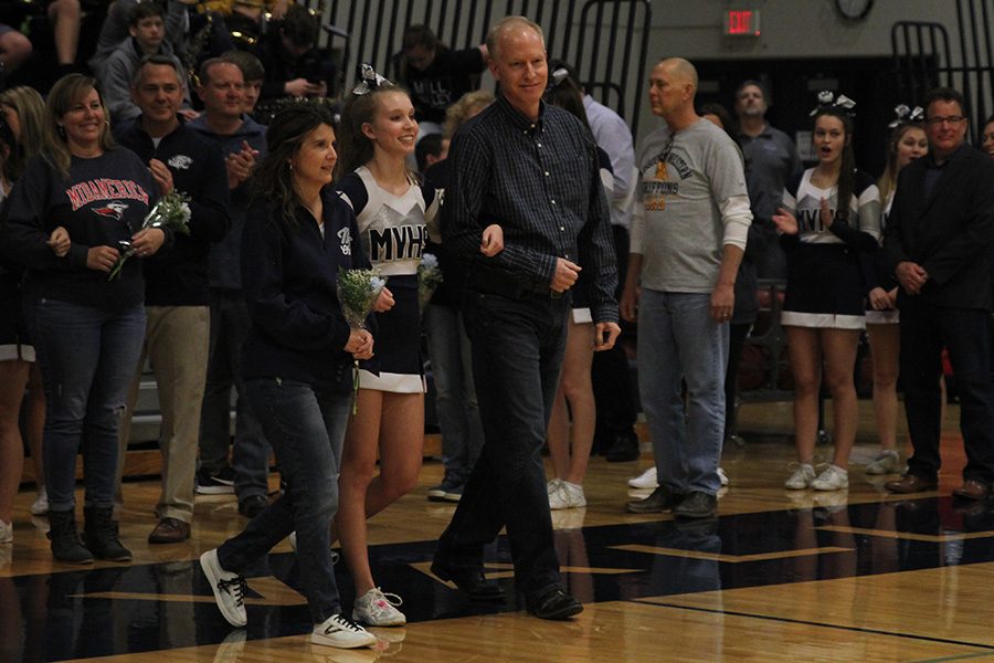 As she is introduced for senior night, senior Kate Backes walks out with her parents.