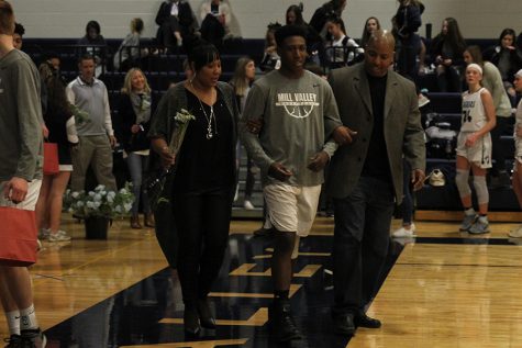 As he is introduced for senior night, senior Trey Dameron walks out with his parents.