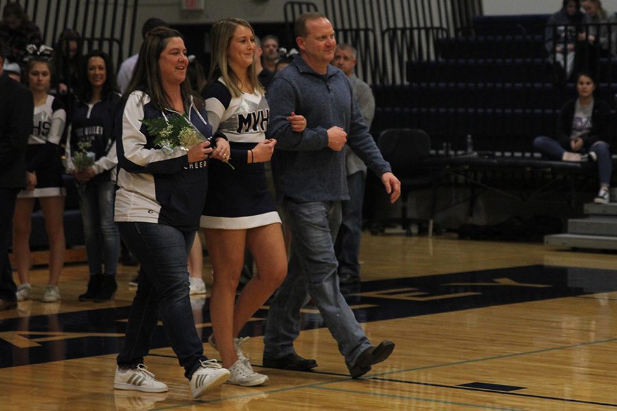 As she is introduced for senior night, senior Lexi Knappen walks out with her parents.