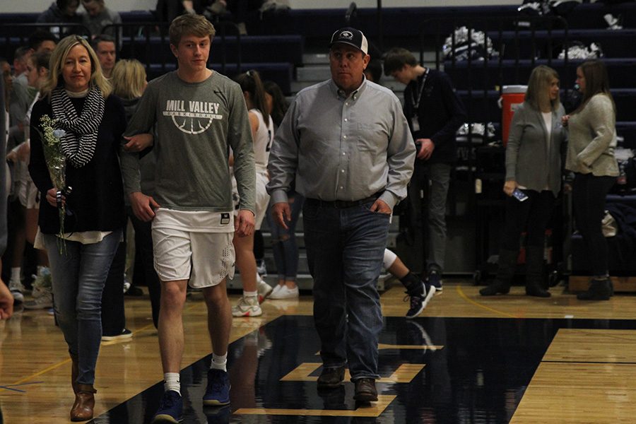 As he is introduced for senior night, senior Nick Davie walks out with his parents.