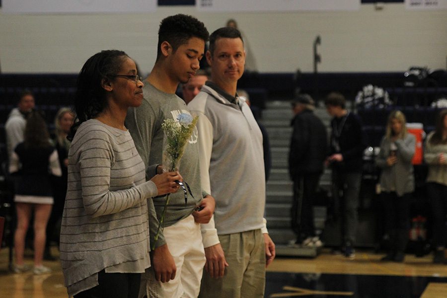 As he is introduced for senior night, senior Seth Hobson walks out with his parents.