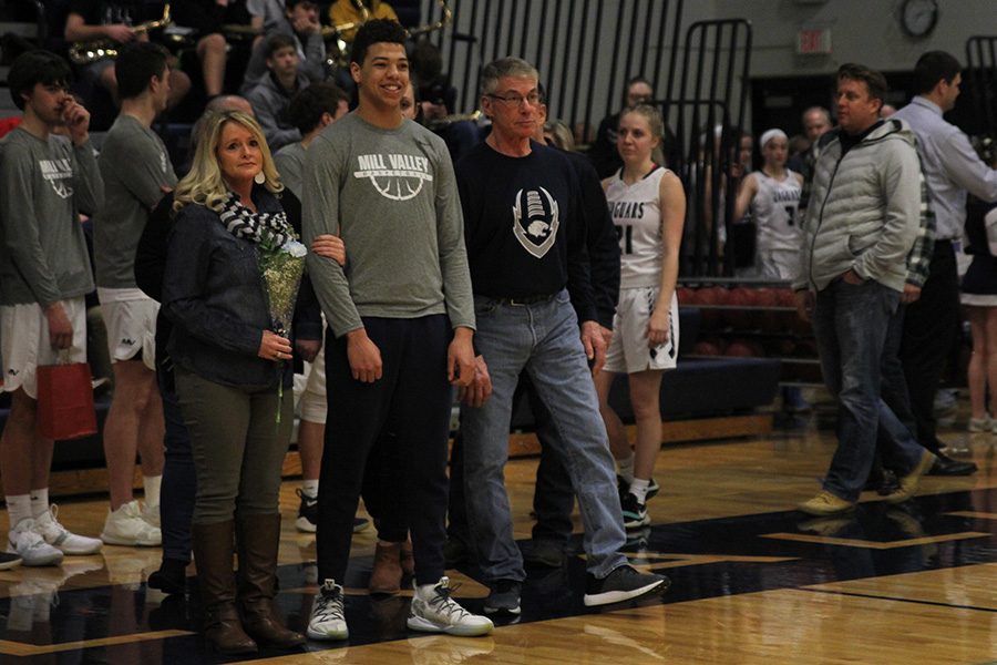 As he is introduced for senior night, senior Matty Wittenauer  walks out with his parents.