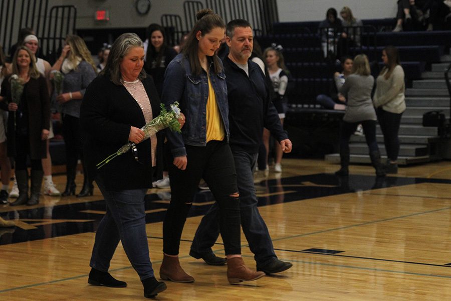 As she is introduced for senior night, senior Makayla King walks out with her parents.