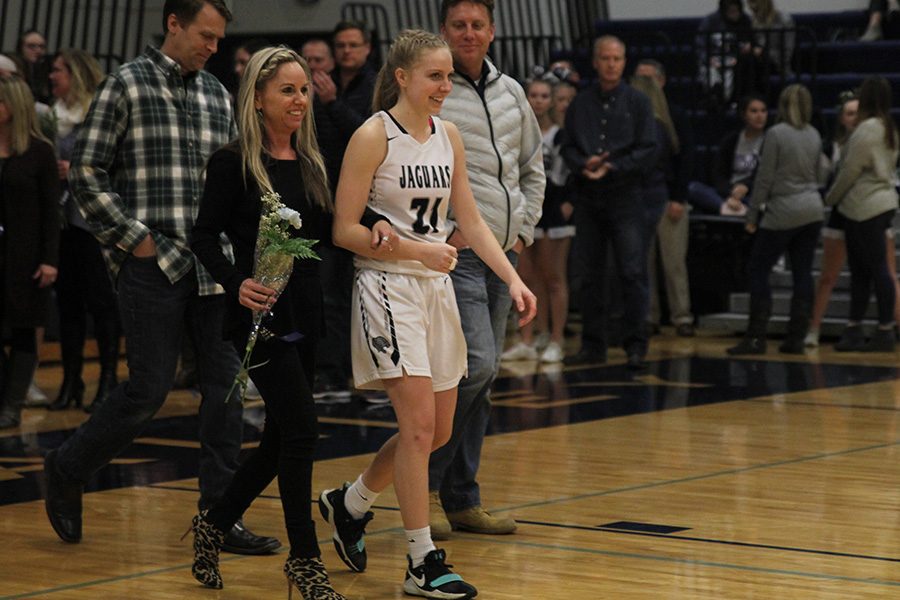 As she is introduced for senior night, senior Lexi Ballard walks out with her parents.