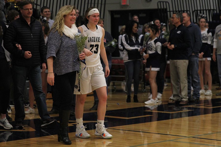 As she is introduced for senior night, senior Claire Kaifes walks out with her parents.