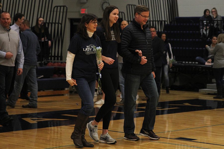 As she is introduced for senior night, senior Trinity Knapp walks out with her parents.