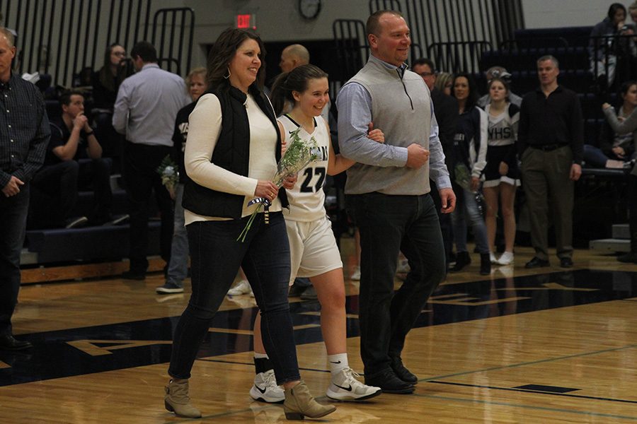 As she is introduced for senior night, senior Sydney Stuke walks out with her parents.