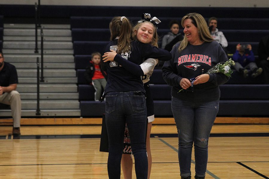 After she was introduced for senior night, senior Faith Dmyterko hugs a fellow cheerleader.