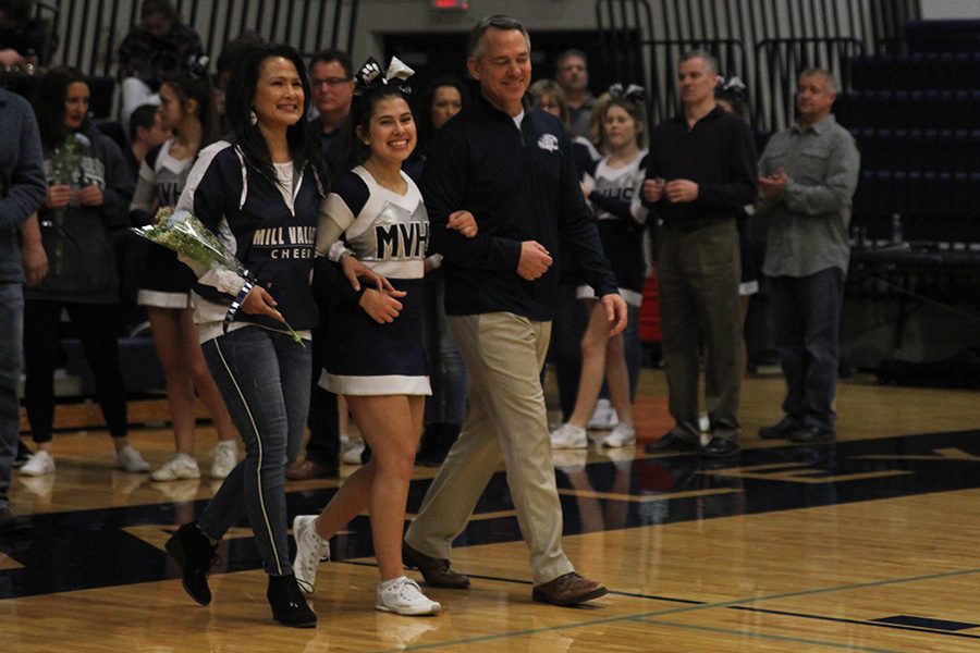 As she is introduced for senior night, senior Mya Johnston walks out with her parents.