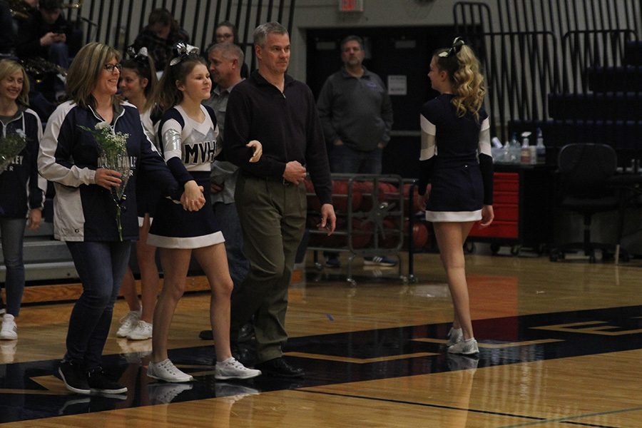 As she is introduced for senior night, senior Rielly Rittmann walks out with her parents.