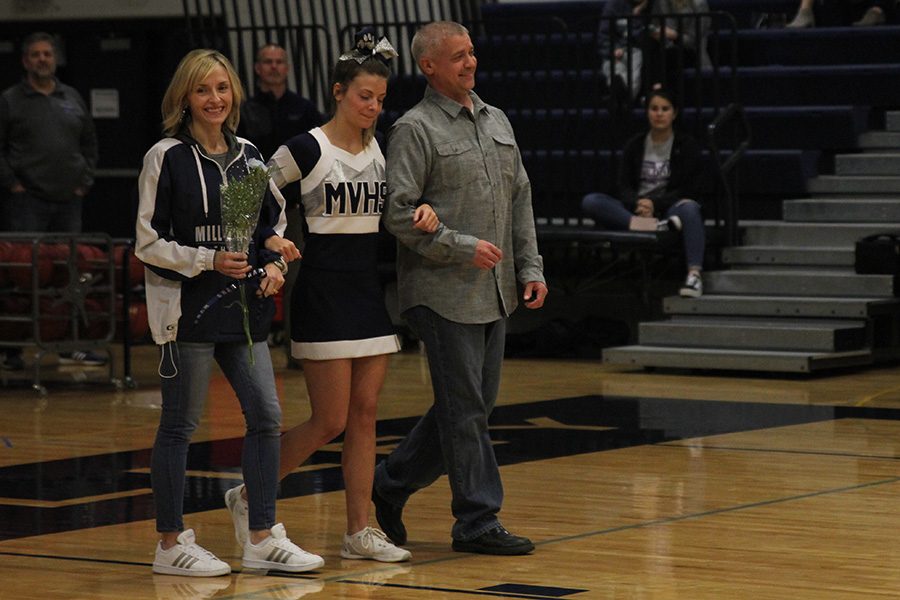 As she is introduced for senior night, senior Payton Totzke walks out with her parents.