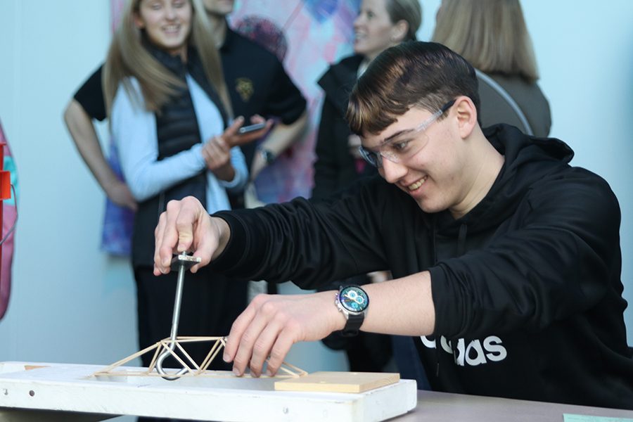 Attaching the hook to his bridge, senior Johannes Seberger prepares to test his bridge.