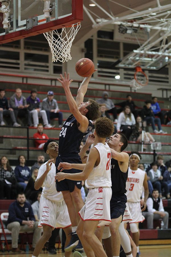 Shooting a layup, junior Jack McGuire attempts to score.