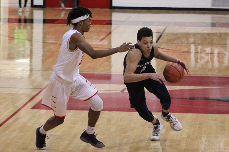 As his opponent trying to stop him, senior Matty Wittenauer makes a hard drive towards the basket. In the first round of substate against Shawnee Mission North on Monday, Feb. 25 the Jags fell with a final score of 55-46.