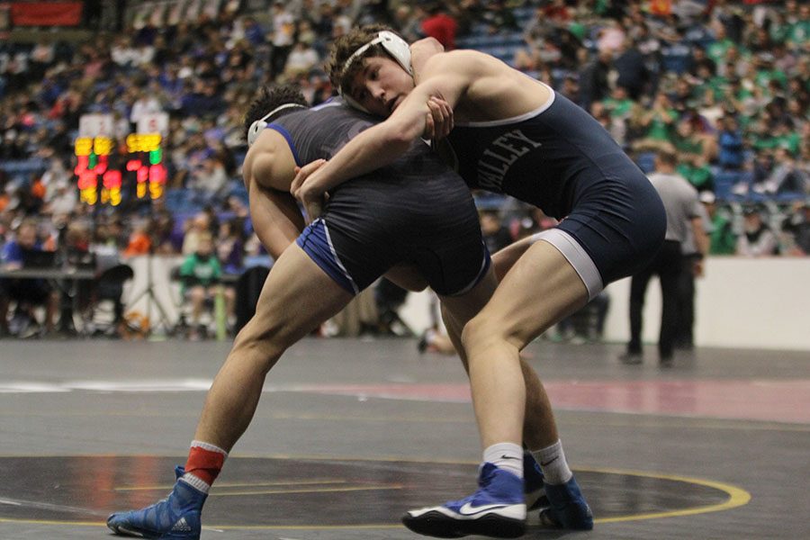 With his arms around his opponents waist, sophomore Brodie Scott attempts to take him down.