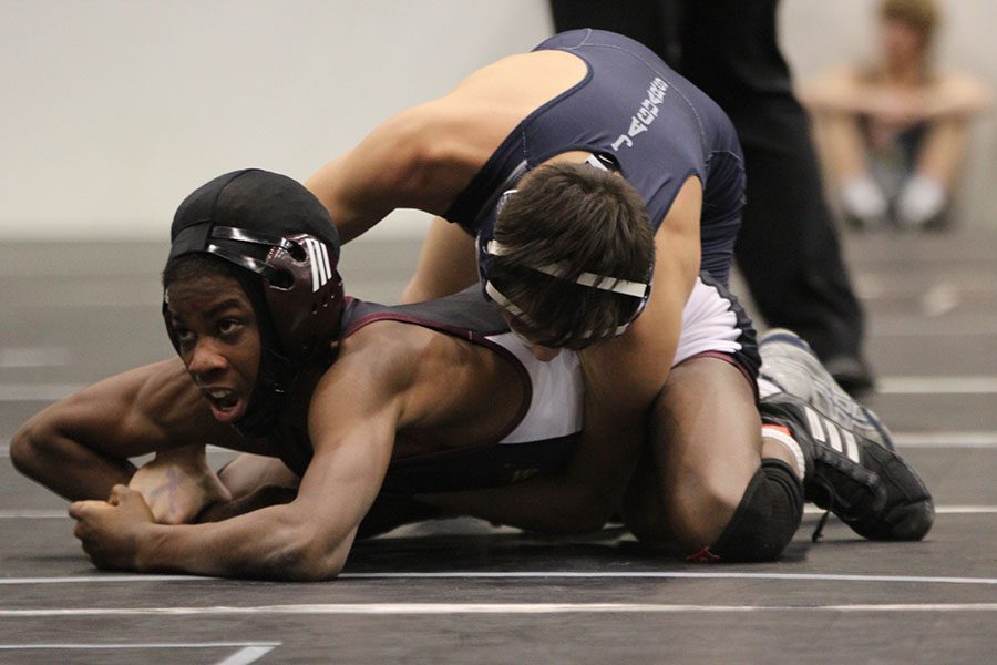 With his opponent under him, sophomore Liam Sutton tries to hold him down.