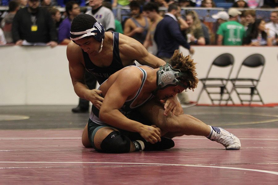With his opponent under him, junior Tyler Green tries to force him to the ground to get a pin.