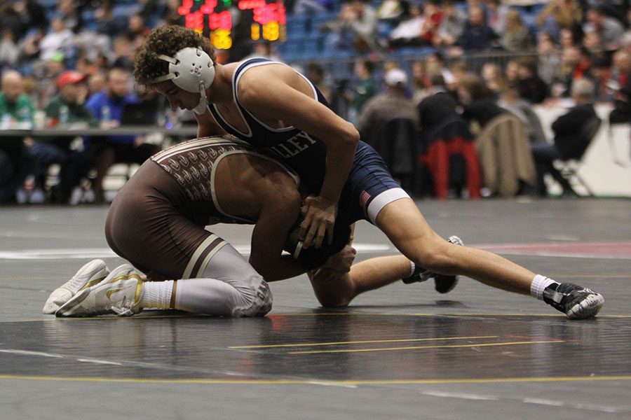 With his opponent beneath him, junior Zach Keal tries to push his head to the ground