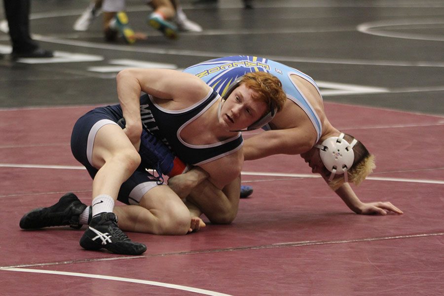 While holding his opponent down, sophomore Carson Dulitz looks for direction from his coaches.