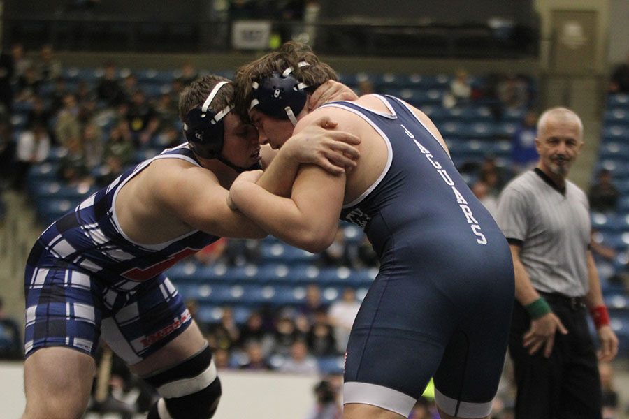 Face-to-face with his opponent, sophomore Ethan Kremer tries to push him down.