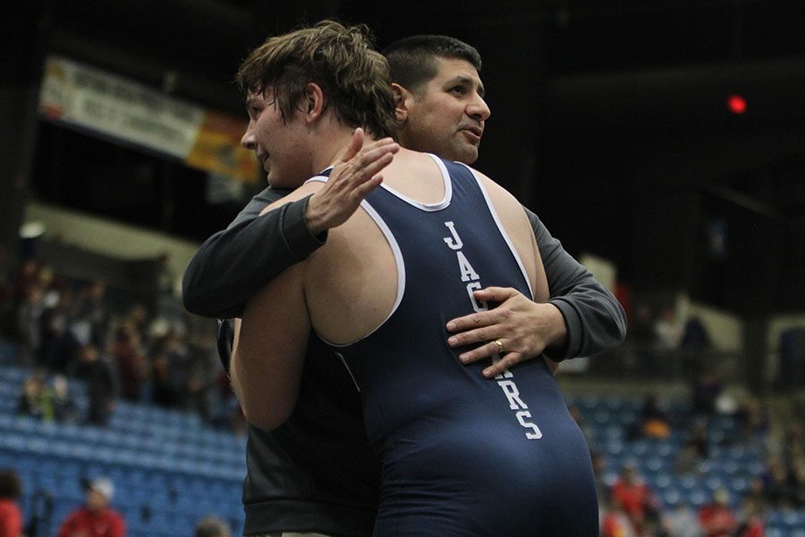 After winning the state championship title, sophomore Ethan Kremer embraces head wrestling coach Travis Keal.