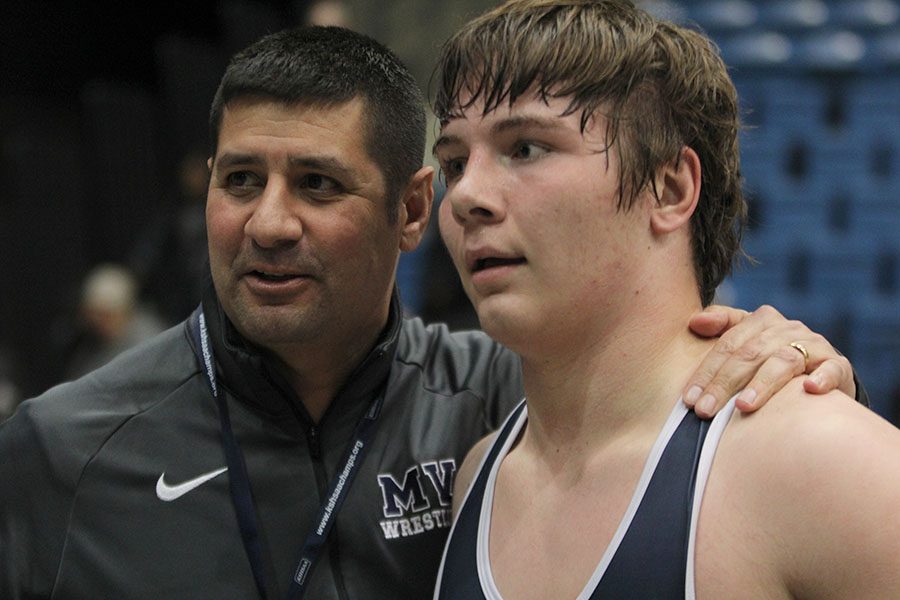 After sophomore Ethan Kremer won the state title, head wrestling coach Travis Keal congratulates him.