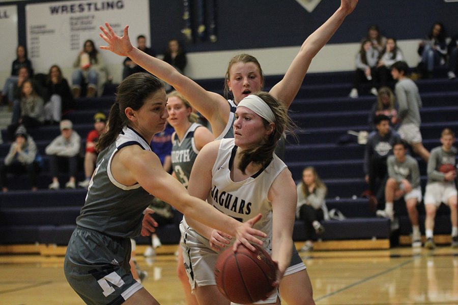 Trapped by defenders, senior Claire Kaifes attempts to hand the ball off. 