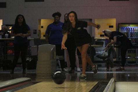 During warmups, sophomore Peyton Wagoner releases the bowling ball sending it town the pins.