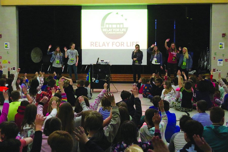 Elementary school students raise their hands after senior Abby Hoepner asked who knows somebody affected by cancer during the Relay for Life community presentation at Horizon Elementary on Tuesday, Feb. 26
